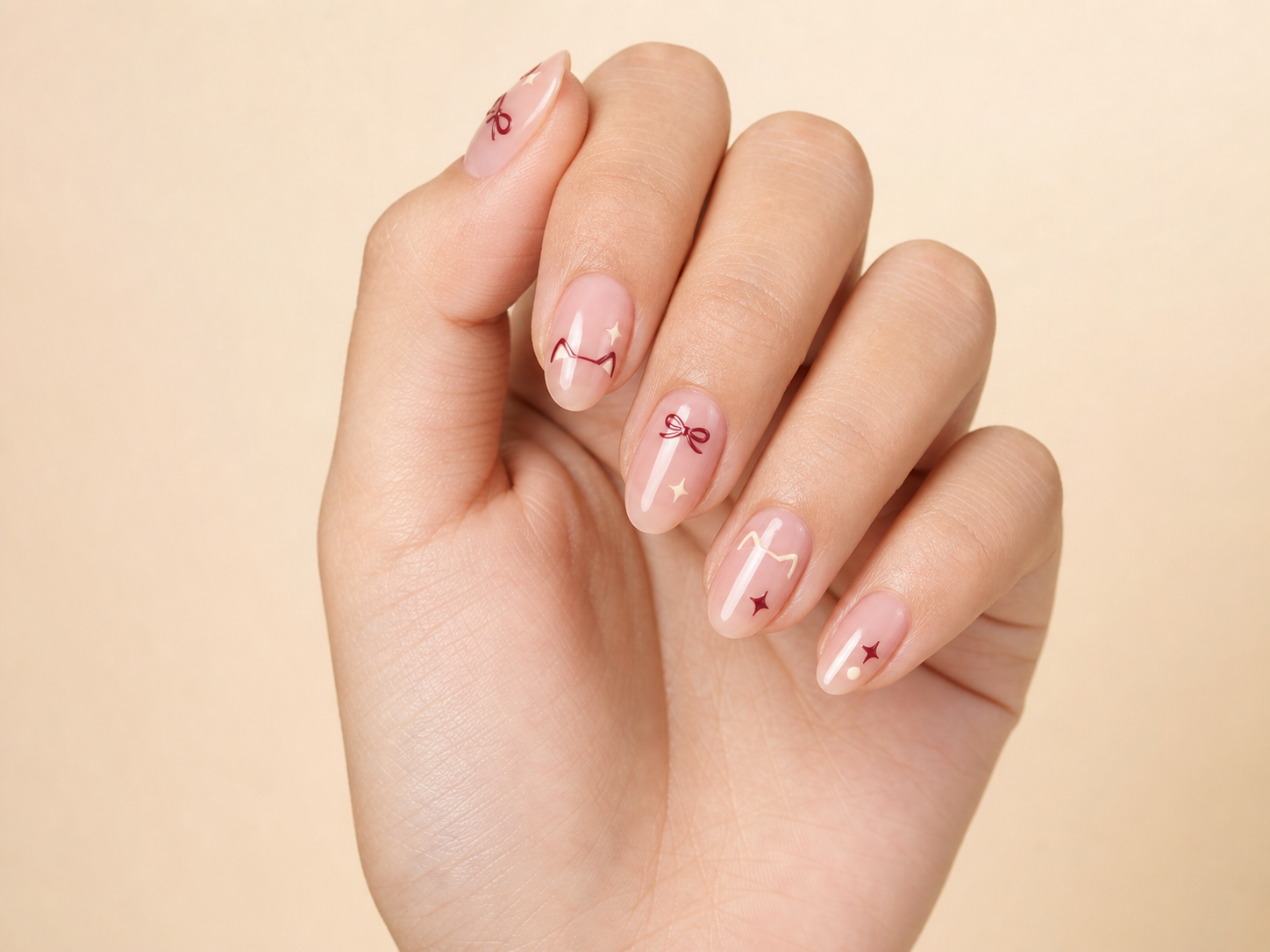 Uñas con gel rosa y nail art de moños y estrellas